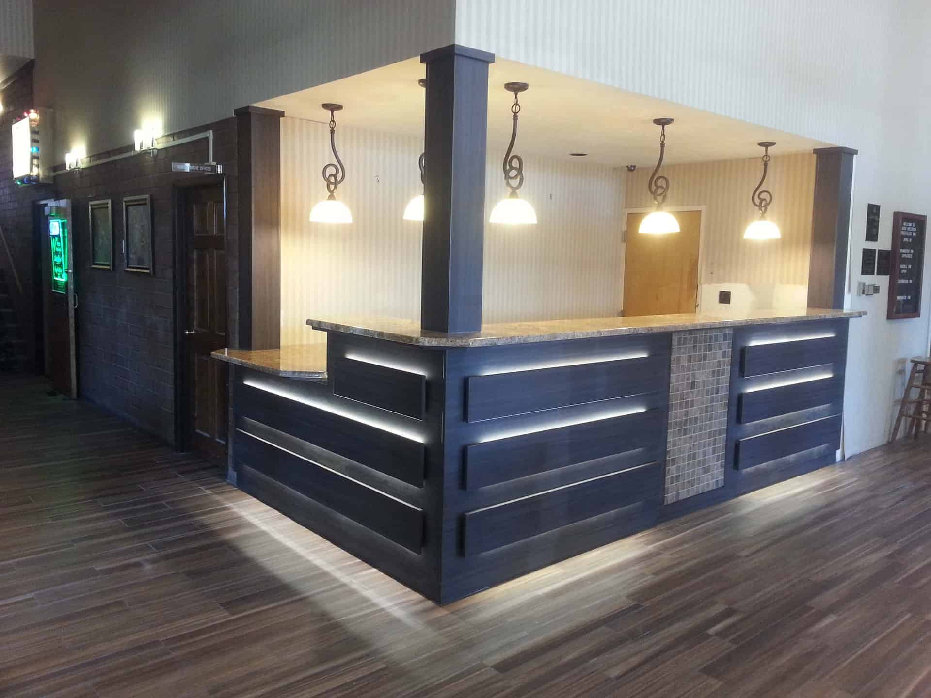 Blue colored wooden front desk in a lobby - Laminate countertops.