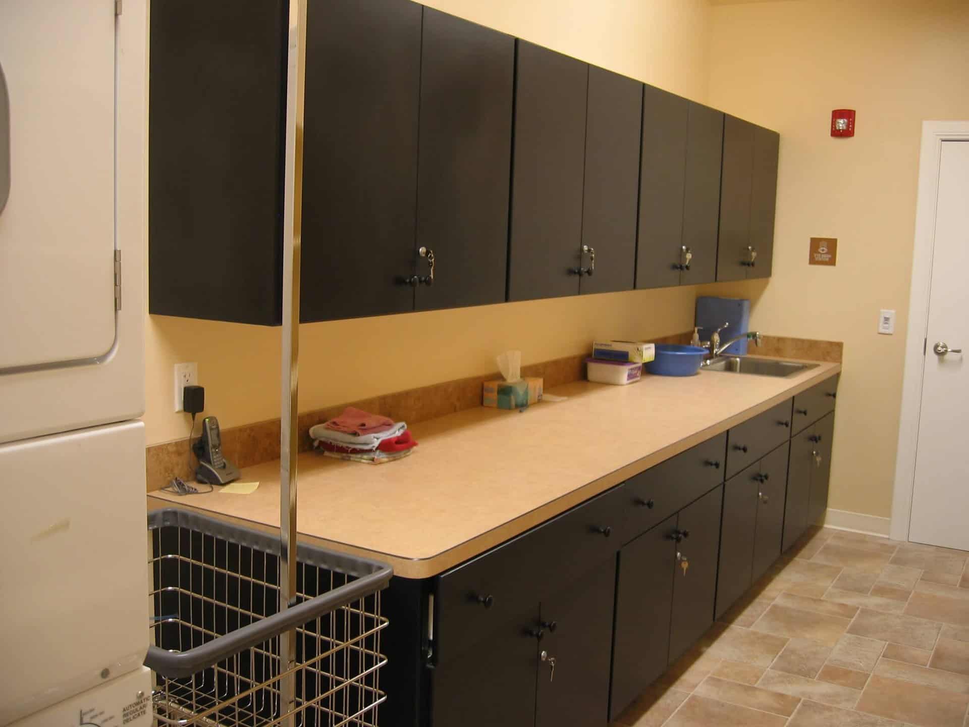 Dark Wooden kitchen cabinet with laminate countertop in an office.